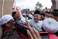 Anwar (tengah) menyantuni jemaah selepas menunaikan solat Jumaat di Masjid Jumhuriah, Taman Dato Harun. Turut kelihatan, Menteri Besar Selangor Datuk Seri Amirudin Shari. - Foto Bernama