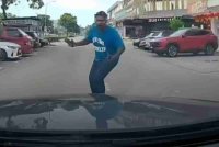Tangkap layar seorang pejalan kaki yang meluru secara tiba-tiba ke arah sebuah kereta yang sedang bergerak melalui Jalan Austin Heights 8/2, di Johor Bahru pada Khamis.