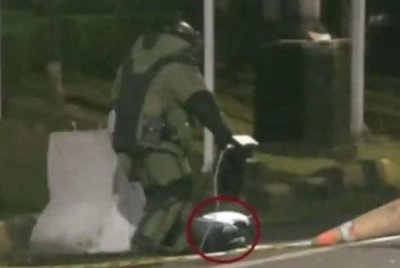 Anggota pemusnah bom lengkap berpakaian bak angkasawan kemudiannya tiba di kawasan itu untuk memeriksa kandungan beg berkenaan. Foto Agensi