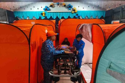 Anggota APM Raub membantu proses pemindahan mangsa banjir di PPS SK Ulu Atok, Raub.Foto APM Pahang 