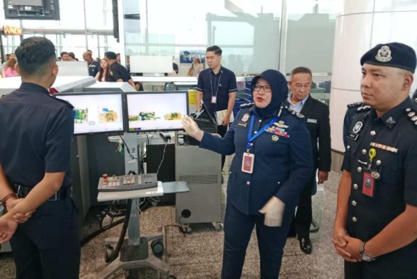Anis Rizana (tengah) ketika melakukan lawatan di sekitar pintu pelepasan penumpang di KLIA pada Jumaat.