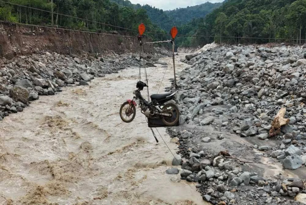 Kabel keluli dengan sistem takal digunakan untuk mengangkut motosikal menyeberangi sungai.