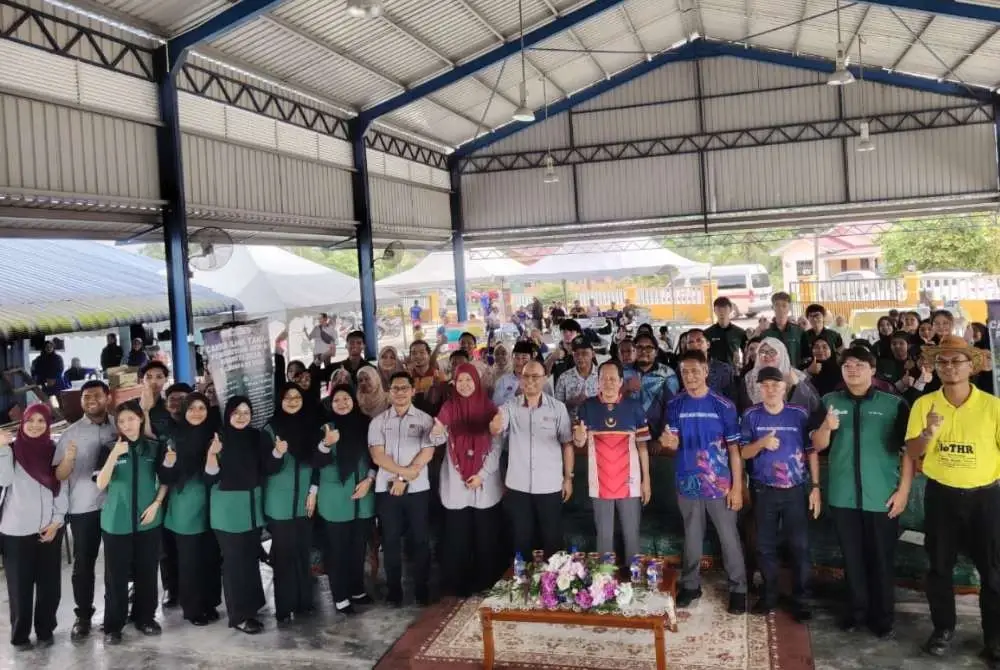 Ahmad (lima dari kanan) bergambar dengan penduduk kampung dan penuntut selepas perasmian program Cakna Ilmu Tanah di Kampung Parit Dato Onn, Pontian.