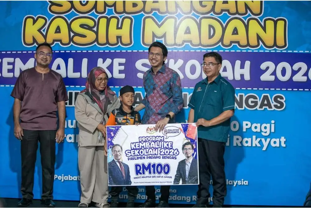 Ainul Bariah menemani anaknya, Aliff Aqasyah Mohamad Sukri, 9, menerima Sumbangan Kasih Madani, Kembali ke Sekolah Parlimen Padang Rengas 2026 yang disampaikan Muhammad Kamil.