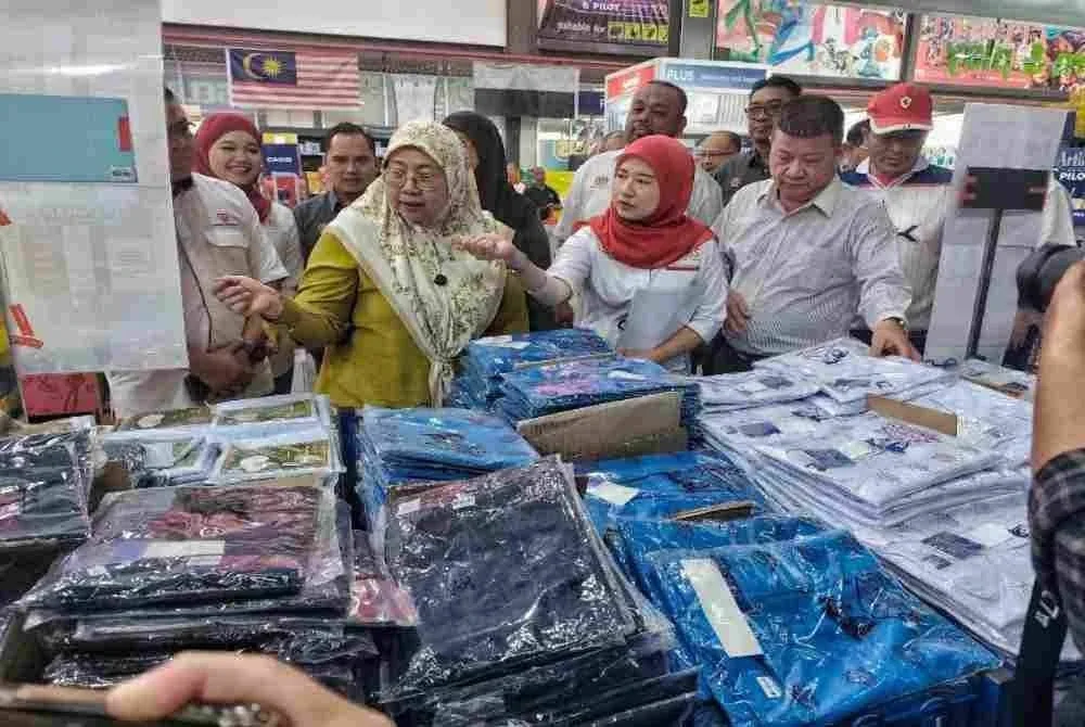 Fuziah memeriksa harga pakaian seragam sekolah selepas program serahan baucar kembali ke sekolah 2026 di sini pada Ahad. Foto Sinar Harian.