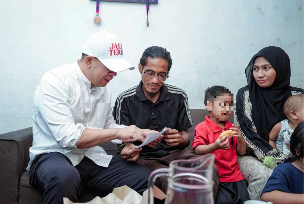 Mohd Hilmi menunjukkan slip gaji kepada Steven ketika Ahli Parlimen Bukit Mertajam itu menziarahi keluarga berkenaan. Foto FB Steven Sim