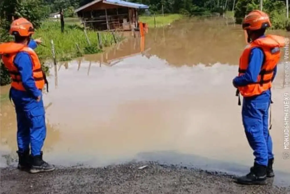 Anggota APM memantau kawasan kampung dinaiki air di Tenom.