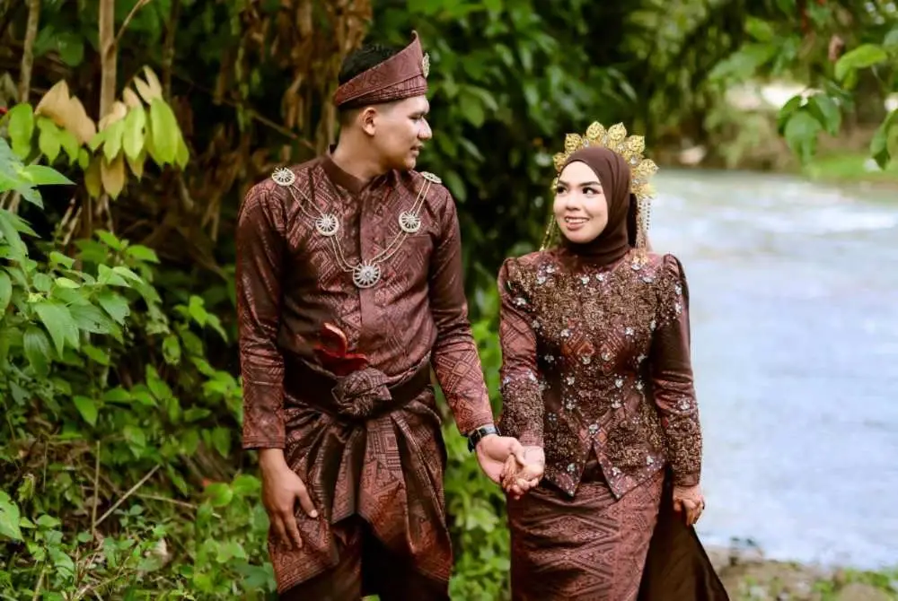Wan Jamilah (kanan) dan Mohd Faris Haikal (kiri) bergambar kenangan majlis perkahwinan mereka.