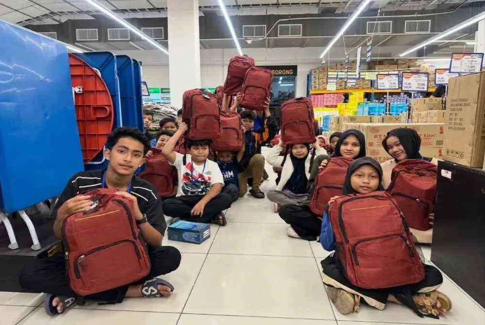 Muhammad Zarhan (kiri) bersama penerima memegang beg sekolah yang baru dibeli. Foto: SINAR HARIAN/ADILA SHARINNI WAHID