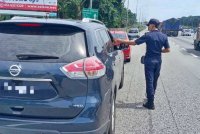 Penguat kuasa JPJ menahan kenderaan yang menggunakan lorong kecemasan. - Foto JPJ