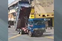 Tangkap layar video tular memaparkan timbau lori pasir tidak diturunkan sebelum merempuh lampu isyarat dan kabel elektrik di Pekan Nenas, Pontian pada Isnin.