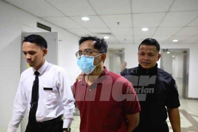 Ahmad Faisal (tengah) dihadapkan ke Mahkamah Sesyen dan Mahkamah Majistret di Kuala Terengganu pada Isnin atas dua pertuduhan menggunakan wang palsu dan cubaan mencuri barang kemas pada Disember tahun lalu.