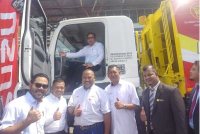 Ramli (berdiri tiga dari kiri) bergambar semasa Program Penyerahan Lori Kompaktor dan Armroll KDEBWM di Stadium Sungai Besar pada Isnin.