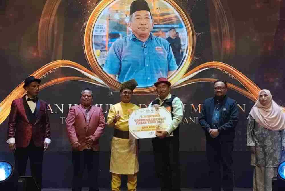 Abdul Rashid (tiga dari kiri) menyampaikan anugerah Tokoh Usahawan Pasar Tani kepada Muhaddis (tiga dari kanan) pada Majlis Seuntai Kasih bersama peniaga Pasar Tani Selangor, Wilayah Persekutuan Kuala Lumpur dan Putrajaya di Shah Alam pada Isnin malam.