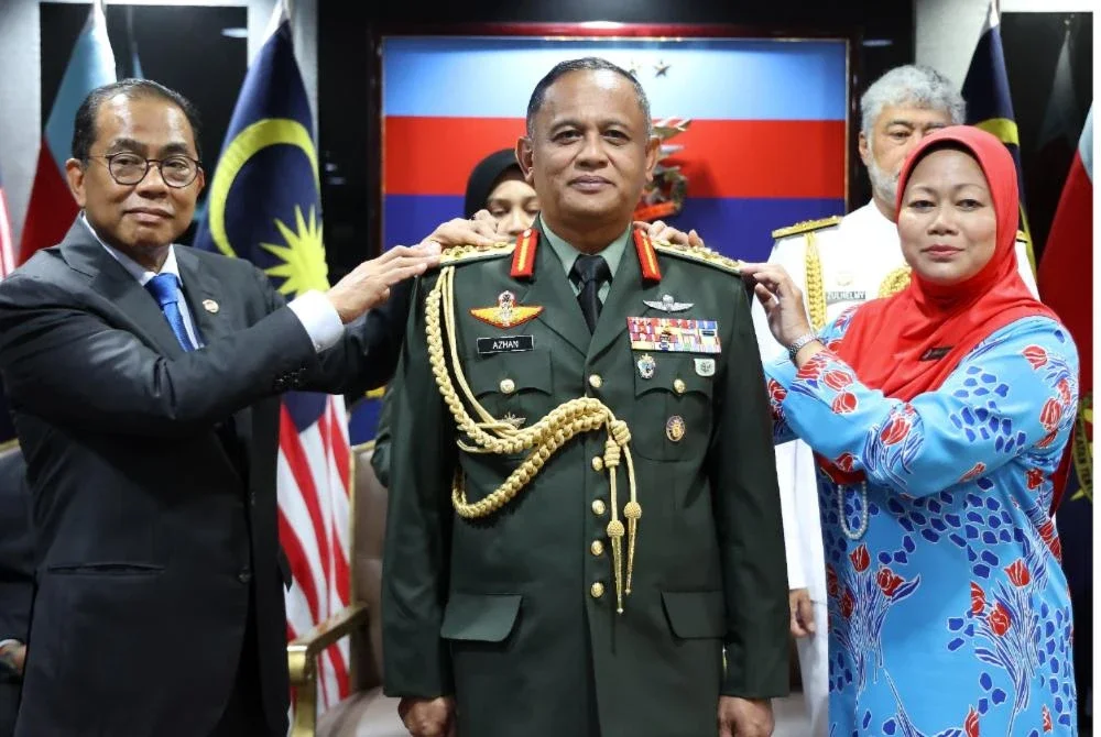 Khaled (kiri) dan isteri PTD, Datin Noor Ainy Mohd Ali (kanan) memakaikan pangkat kepada Azhan ketika Majlis Pemakaian Pangkat Panglima Tentera Darat Ke-31 di Wisma Pertahanan, Kuala Lumpur pada Selasa.