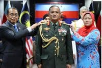 Khaled (kiri) dan isteri PTD, Datin Noor Ainy Mohd Ali (kanan) memakaikan pangkat kepada Azhan ketika Majlis Pemakaian Pangkat Panglima Tentera Darat Ke-31 di Wisma Pertahanan, Kuala Lumpur pada Selasa.