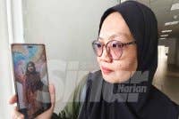 Ayu Zana menunjukkan gambar anaknya, pelajar UiTM Merbok, Nur Ain Zulaisya yang maut kemalangan bersama sahabatnya. 