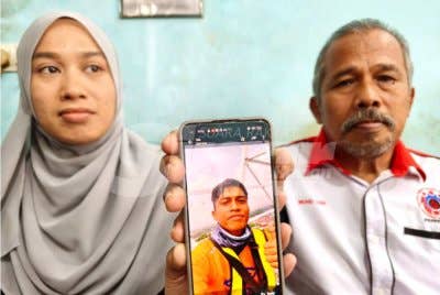 Mohd Zain (kanan) dan Annurfatinah menunjukkan gambar arwah Amirrulmukminin semasa ditemui di rumah mereka di Perumahan Desa Darulnaim, Pasir Tumbuh, Kota Bharu pada Selasa. - Foto Sinar Harian/Hazelen Liana Kamarudin