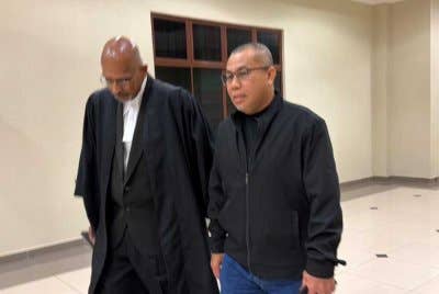 Sheikh Hassan (kanan) bersama peguam selepas dilepas dan dibebaskan daripada 10 tuduhan salah guna kuasa.