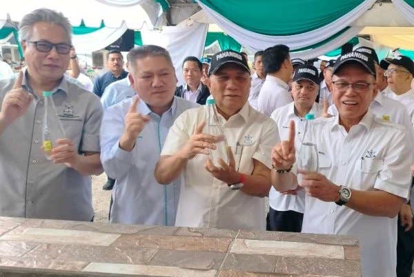 Wan Rosdy (kanan) menunjukkan air mineral dari telaga pertama yang digali di tanah milik Yayasan Pahang di Ladang Gambang pada Selasa