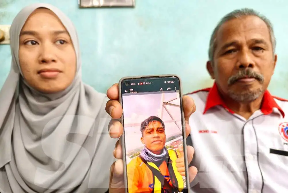 Mohd Zain (kanan) menunjukkan gambar arwah Amirrulmukminin semasa ditemui di rumah mereka di Perumahan Desa Darulnaim, Pasir Tumbuh, Kota Bharu pada Selasa.Foto:SINAR HARIAN/HAZELEN LIANA KAMARUDIN