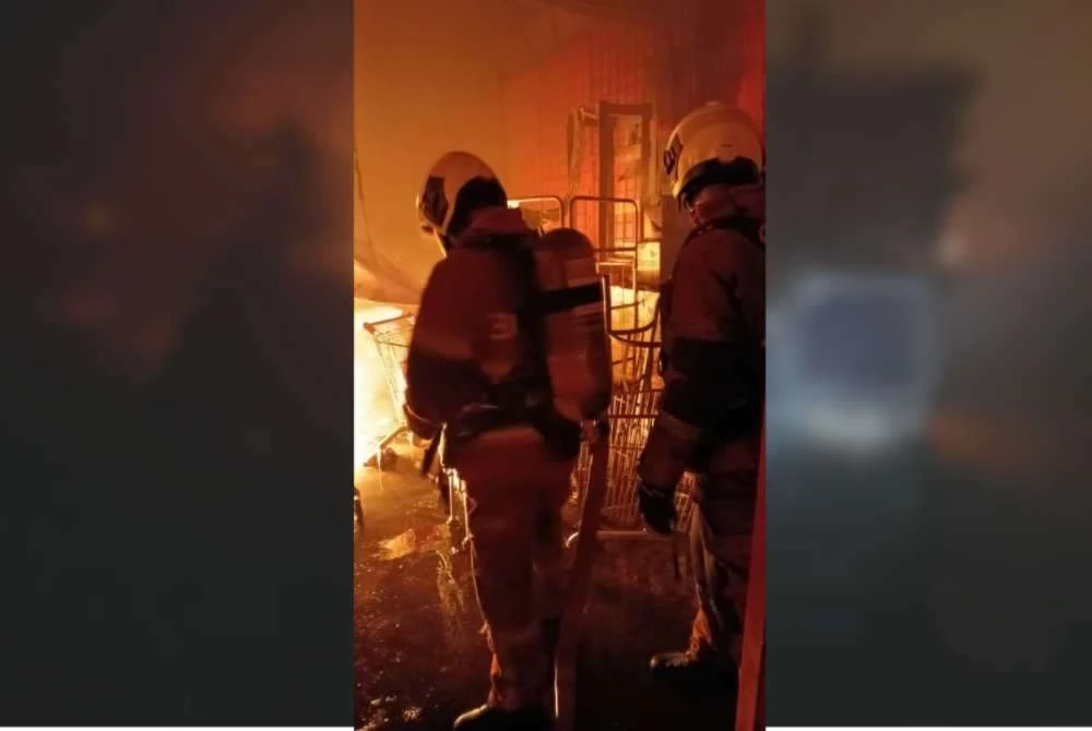 Anggota bomba sedang memadamkan kebakaran sebuah kilang memproses makanan sejuk beku pada Rabu.