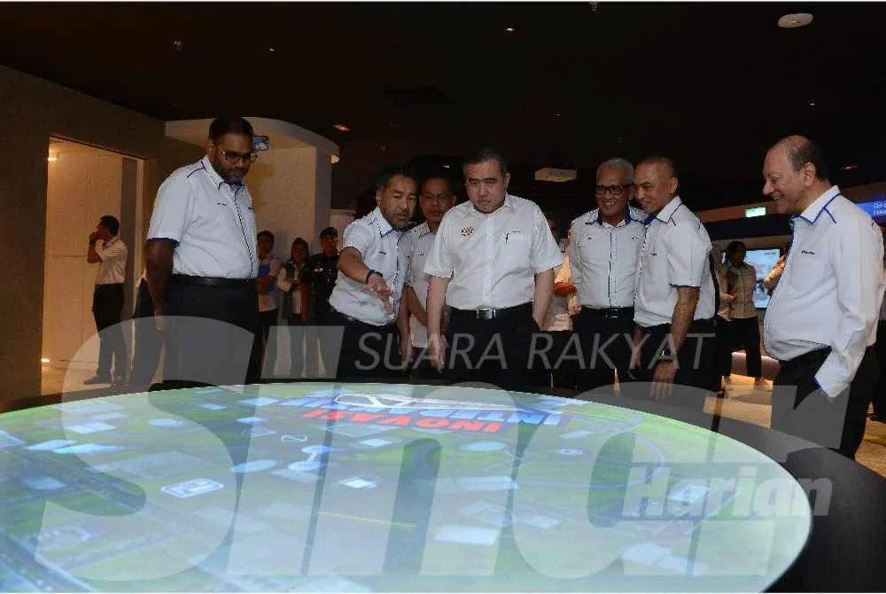 Ketua Unit Kreatif dan Penjenamaan Prasaran, Zulfadli Zainal Abidin (dua dari kiri) memberi penerangan kepada Anthony (tengah). Turut hadir Amir (dua dari kanan) dan Pengerusi Prasarana, Tan Sri Mohd Nasir Ahmad (tiga dari kanan).