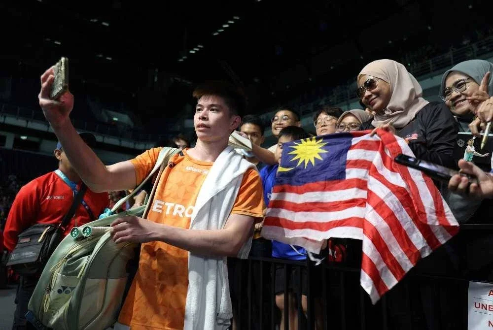 Pemain perseorangan lelaki negara Leong Jun Hao melayan para peminat selepas menentang pemain China, Wang Zheng Xing pada Kejohanan Badminton Terbuka Malaysia 2026. FOTO: BERNAMA