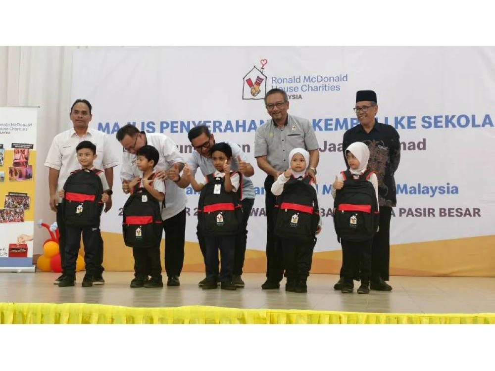 Dari kanan: Zainuddin, Mohd Nasri dan Azmir menyampaikan sumbangan Pek Kembali Ke Sekolah RMCH Malaysia kepada penerima.