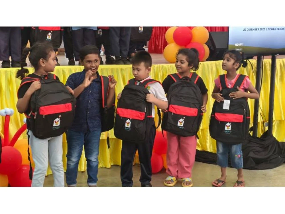 Kanak-kanak seronok memperagakan beg sekolah yang diterima.