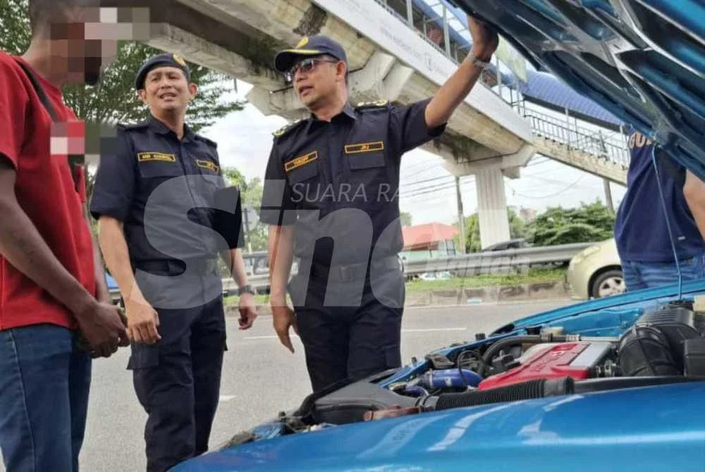 Mohammad Yusoff (kanan) melakukan pemeriksaan ke atas sebuah kenderaan dalam Operasi Pengarah di hadapan SK Tasek di Jalan Sultan Azlan Shah, Ipoh pada Khamis.