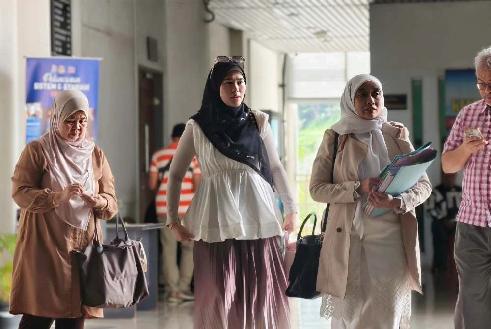 Dr Fie (dua dari kiri) ditemani ibu bapa dan peguamnya ketika hadir ke mahkamah.