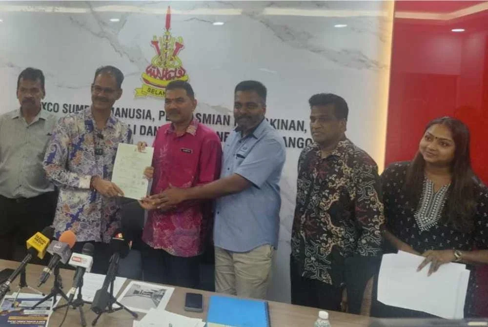 Papparaidu (dua dari kiri) semasa menyerahkan salinan geran hak milik kepada wakil sekolah selepas sidang akhbar pada Khamis.
