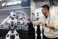 Evan Yao dari EngineAI bergambar bersama robot humanoid EngineAI T800 semasa Pameran Elektronik Pengguna (CES) tahunan di Las Vegas, Nevada.