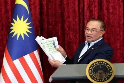 Perdana Menteri, Datuk Seri Anwar Ibrahim memperlihatkan senarai jemaah menteri baharu Kerajaan Madani ketika sidang media khas Pengumuman Anggota Kabinet Baharu di Bangunan Perdana Putra, Putrajaya pada 16 Disember lalu. Foto Bernama 