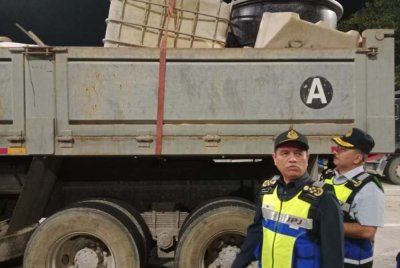 Aedy (kiri) memeriksa kenderaan perdagangan yang ditahan dalam Operasi Khas Kenderaan Perdagangan di R&R Dengkil pada Rabu.