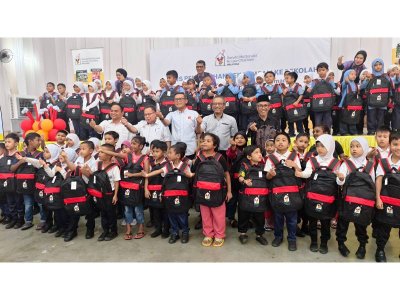 Azmir (tengah) meraikan anak-anak yang menerima bantuan Pek Kembali Ke Sekolah RMCH Malaysia. 