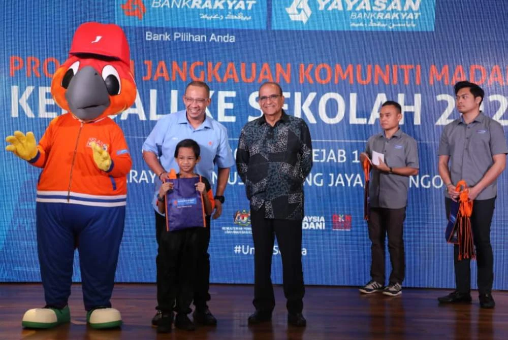 Nizam (dua dari kiri) menyampaikan sumbangan baucar barangan kelengkapan sekolah kepada pelajar B40.