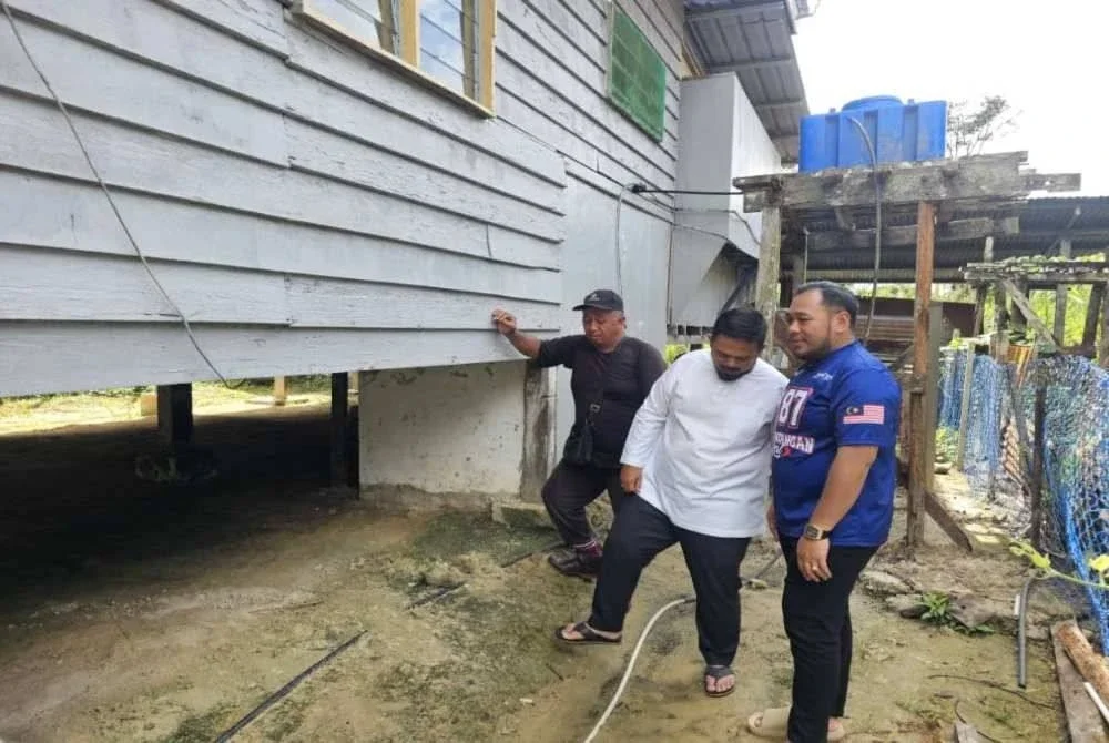 Mohd Naim ketika (kanan) ketika meninjau rumah penduduk yang pernah dibantu oleh arwah Bung Moktar semasa hayatnya di Kampung Bilit, Sukau.
