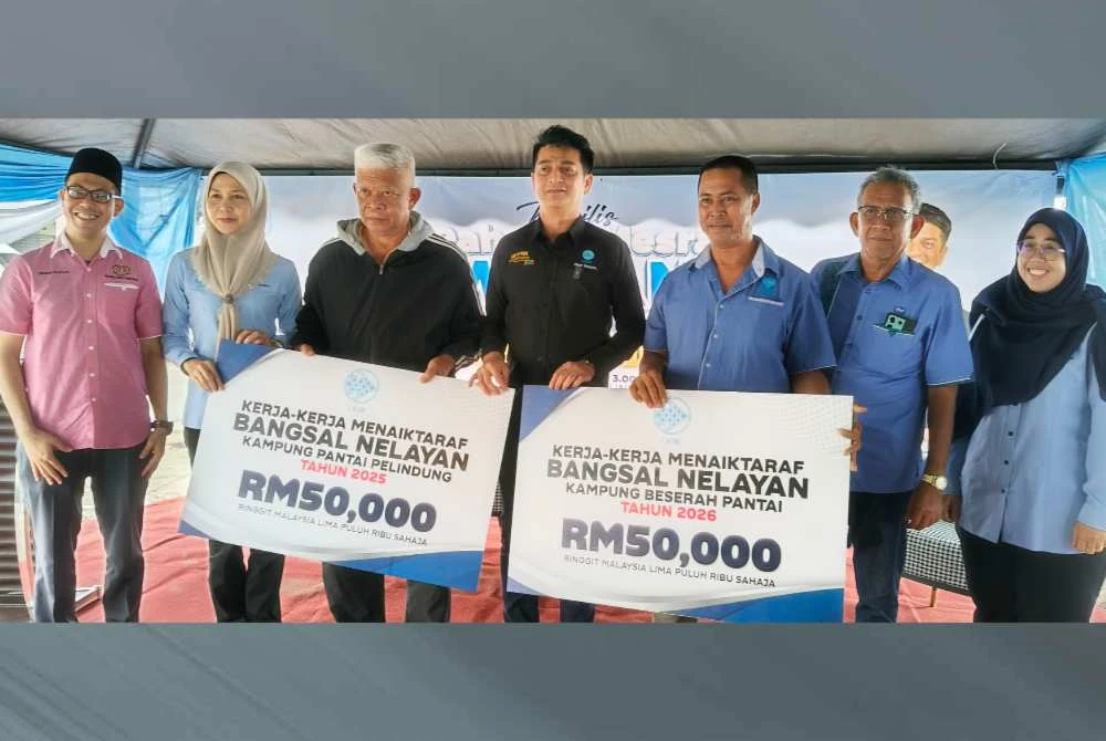 Muhammad Faiz (tengah) menyerahkan peruntukkan RM50,000 bagi naik taraf bangsal nelayan Kampung Beserah dan bangsal nelayan Kampung Pelindung Pantai kepada wakil nelayan.