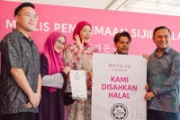 Ryzal (dua dari kanan) dan Maryam (tengah) menerima replika logo halal daripada Penolong Pengarah Kanan Bahagian Advokasi, Bahagian Pengurusan Halal Jakim,
Ustaz Imran Abdul Rahman (kanan).
