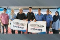 Muhammad Faiz (tengah) menyerahkan peruntukkan RM50,000 bagi naik taraf bangsal nelayan Kampung Beserah dan bangsal nelayan Kampung Pelindung Pantai kepada wakil nelayan.