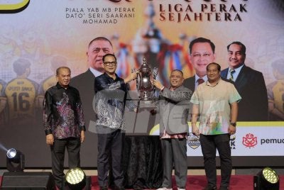 Saarani (dua dari kanan) dan Mohd Azhar (dua dari kiri) mengangkat piala yang akan menjadi rebutan 24 pasukan ketika Majlis Pelancaran Liga Perak Sejahtera Inter Parlimen di Hotel Casuarina @ Meru pada Khamis.