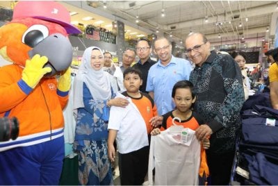 Nizam (dua dari kanan) menyantuni pelajar B40 ketika mencuba baju sekolah.