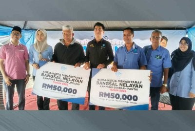 Muhammad Faiz (tengah) menyerahkan peruntukkan RM50,000 bagi naik taraf bangsal nelayan Kampung Beserah dan bangsal nelayan Kampung Pelindung Pantai kepada wakil nelayan.