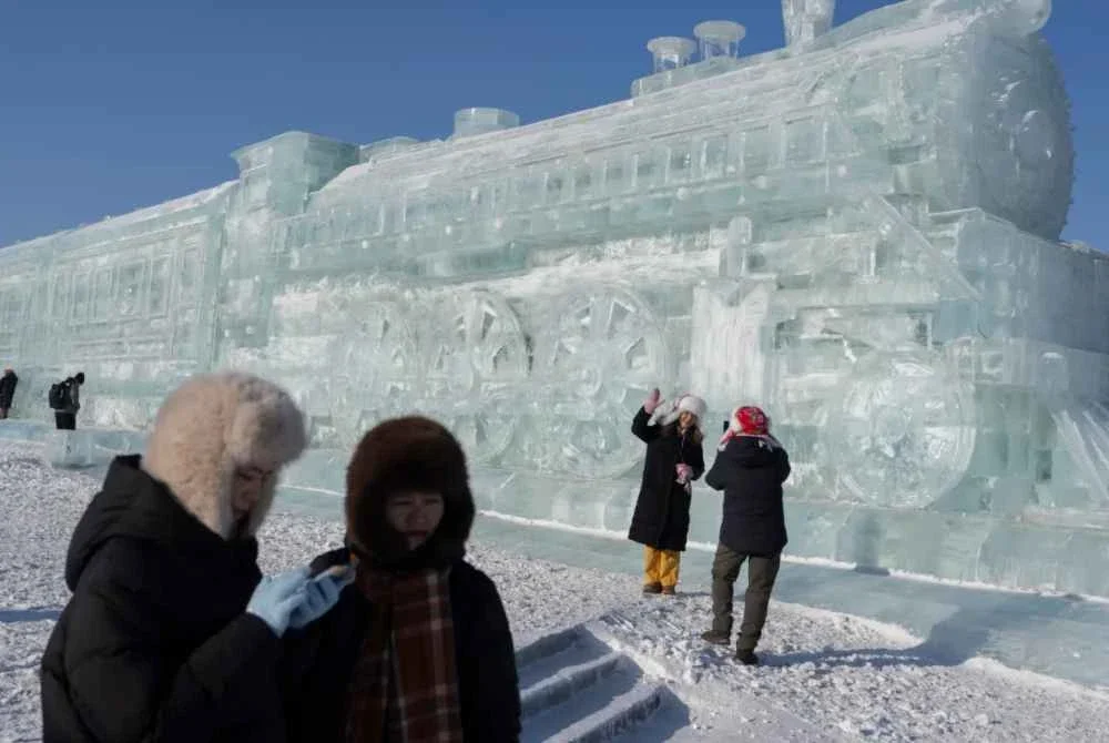 Pengunjung teruja untuk merakamkan foto berlatarbelakangkan arca ais gergasi berbentuk kereta api. Foto Agensi