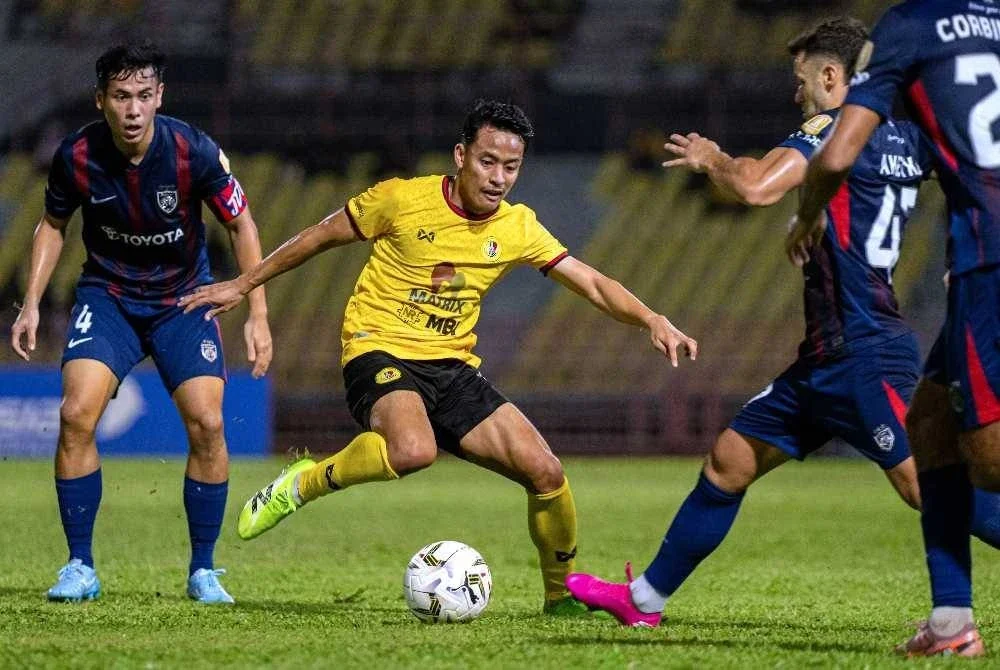 Pemain Negeri Sembilan FC, Luqman Hakim Shamsudin (tengah) cuba melepasi pemain Johor Darul Ta’zim pada perlawanan Liga Super di Stadium Tuanku Abdul Rahman Paroi pada malam Jumaat. Foto Bernama