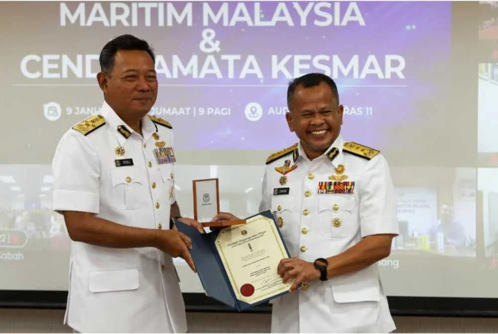 Mohd Rosli (kiri) menyampaikan pingat Dua Dekad Maritim Malaysia kepada Pemangku Timbalan Ketua Pengarah (Operasi) Maritim Malaysia, Laksamana Muda Maritim Mohd Zawawi Abdullah pada Jumaat
