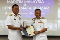 Mohd Rosli (kiri) menyampaikan pingat Dua Dekad Maritim Malaysia kepada Pemangku Timbalan Ketua Pengarah (Operasi) Maritim Malaysia, Laksamana Muda Maritim Mohd Zawawi Abdullah pada Jumaat