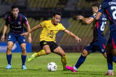 Pemain Negeri Sembilan FC, Luqman Hakim Shamsudin (tengah) cuba melepasi pemain Johor Darul Ta’zim pada perlawanan Liga Super di Stadium Tuanku Abdul Rahman Paroi pada malam Jumaat. Foto Bernama